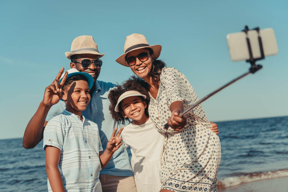 A family of four take a selfie on the beach in family-friendly Fort Lauderdale.